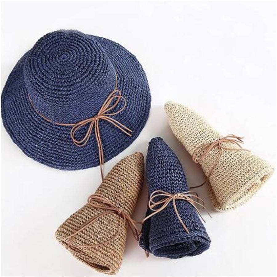 Foldable Raffia Women's Big Brim Beach Hat in navy and beige with bow accents.