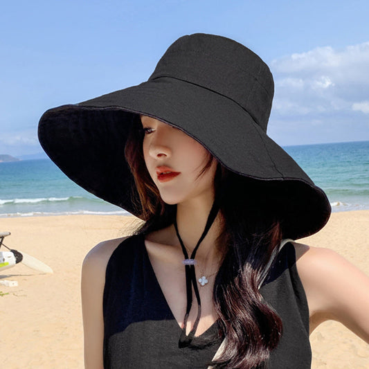 Japanese solid color black fisherman's hat with wide brim for women on beach.